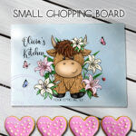 personalised highland cow with pink lily flowers glass chopping board or worktop protector